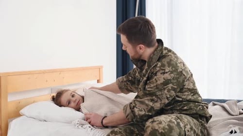 Soldier Father Covers Child with Blanket, Shares Loving Moment
