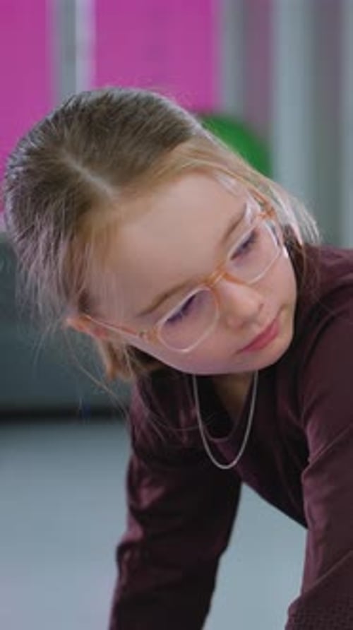 Young Girl Balances Purple Block in Gym Class Session
