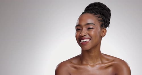 Woman, face and smile with beauty in studio for glowing skin, wellness and detox with makeup