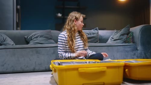 Woman packing suitcase for travel at home