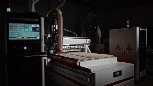 Sturdy Industrial Milling Machine Is Shaping Plywood Panels Under Subdued Lighting Conditions
