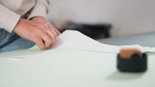 Hands pinning pattern on the table indoors