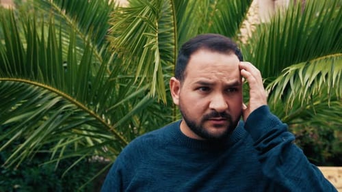 Man Contemplating with Palm Tree Background