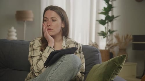 Woman Uses Tablet on Sofa at Home