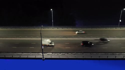 Nighttime Views of Vehicles Traveling Along the Highway with Illuminated Streetlights