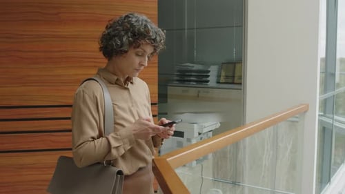 Businesswoman Using Mobile Phone in Modern Office