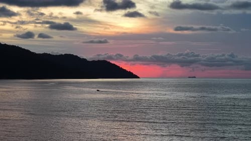 Serene Sunset Over Ocean with Gentle Waves and Dramatic Clouds
