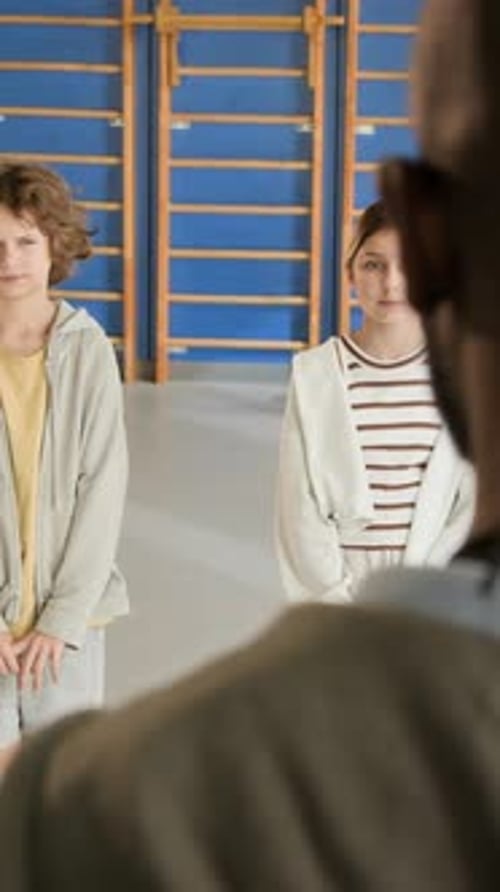 Kids in Row in School Indoor Gym Listening to Teacher Vertical