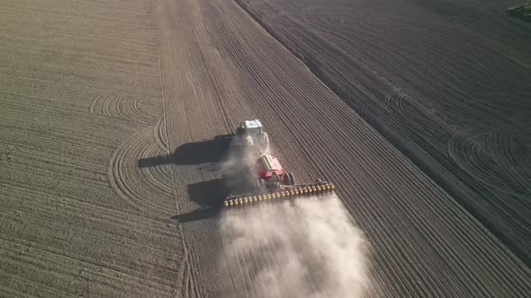 Green tractor works on the field sowing sunflower. Tractor planting ...