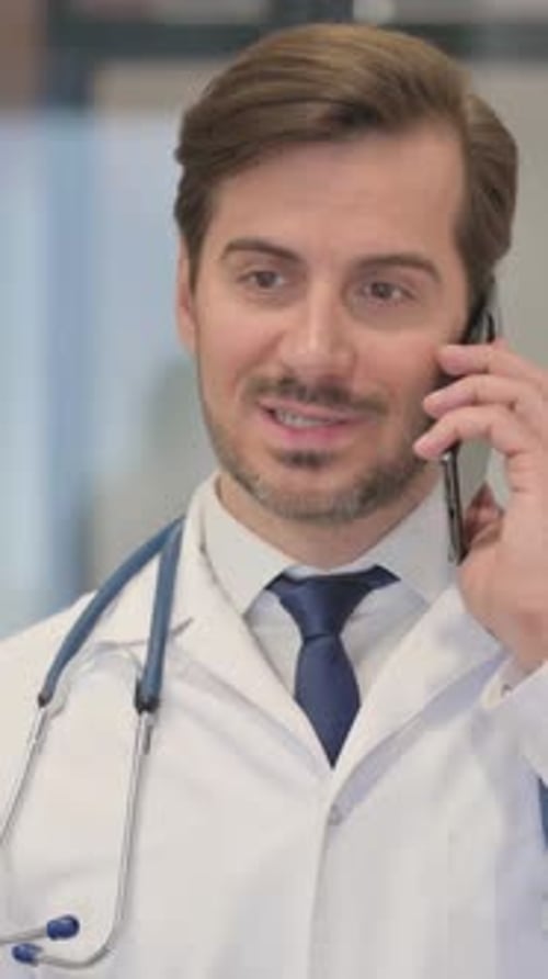 Male Doctor Speaking on Smartphone in Office