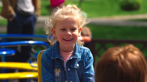 Mother and dougther using the rocking chair at the playground