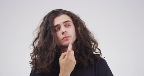 4k video footage of a young man looking thoughtful against a grey background