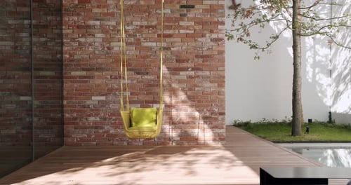 Wicker Garden Swing Chair Hanging Outdoors on Terrace of Modern Cottage House
