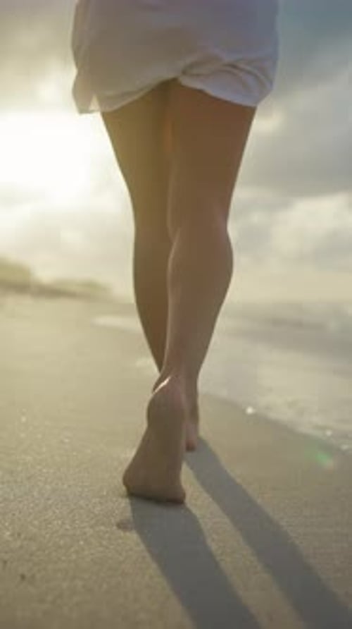 Footprints on Sand Following Shot with Slender Lady Walking on Ocean Shore Female Legs Barefoot
