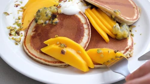 Cutting Into Stack of Pancakes with Toppings