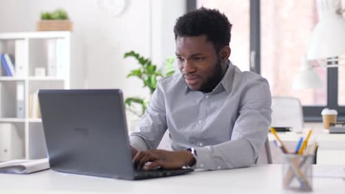 Stressed african american businessman working at computer under deadline pressure