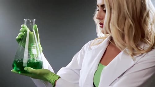 Woman Scientist Holding Green Liquid in Flask