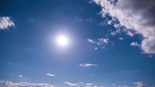 Wolken bewegen sich unter der strahlenden Sonne am blauen Himmel Timelapse