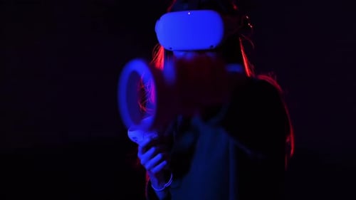 Woman Experiencing Virtual Reality Gaming in Dark Room