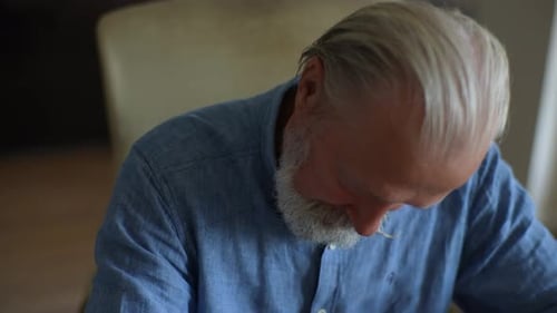 Senior Man Concentrating Indoors Close Up