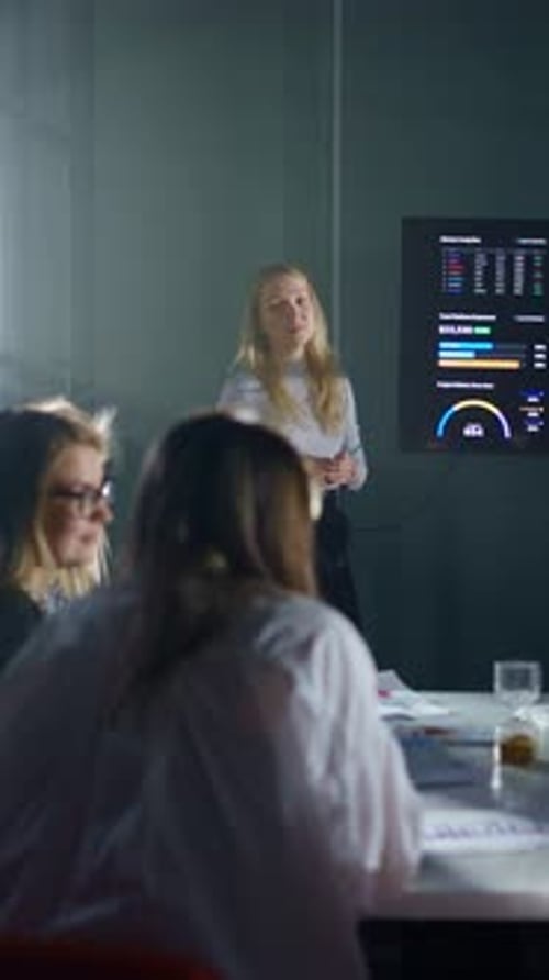 Confident Businesswoman Presenting Digital Analytics Dashboard to Colleagues During Modern Office