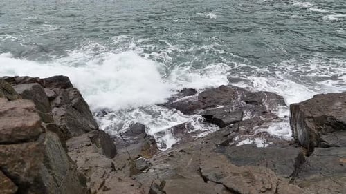 Dynamic Ocean Waves Crashing on Black Stones with Strong Motion
