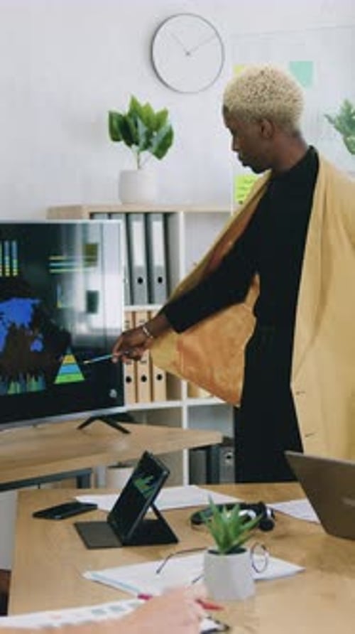 Close Up of Successful African Man Talking and Showing Sheet of Paper with Graphs for Colleagues