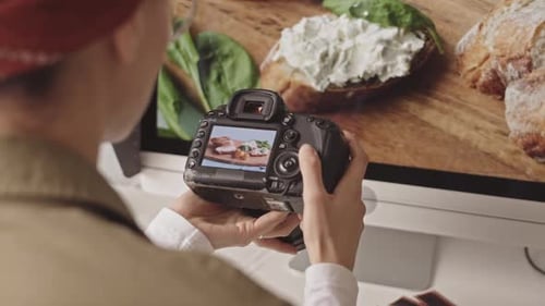 Woman Reviewing Food Photography on Camera at Desk