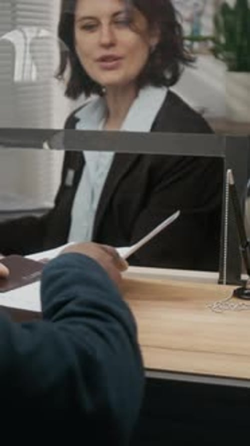 Businesswoman Receives Documents from Client at Office Window
