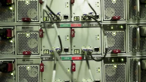 Silver server row with fans and black cables in datacenter, lowering, close-up