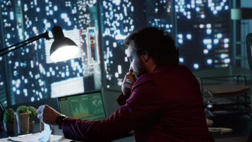 Man Working Late at Desk in Office at Night