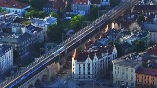 Train Moving Through Urban Landscape from Aerial View