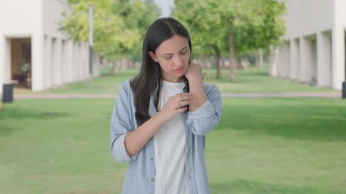 Woman Massages Sore Wrist in Park