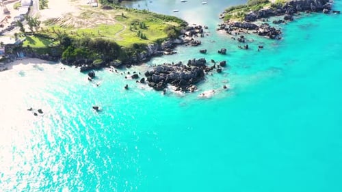 Aerial view of sharp pointy rocks in turquoise water by tropical island. DOWN TO UP.