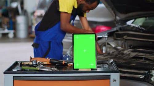 Car Mechanic Next to Green Screen Tablet