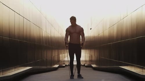 Junger muskulöser Mann, der draußen bei Sonnenuntergang Sport treibt Training eines jungen starken Sportlers Fitness und