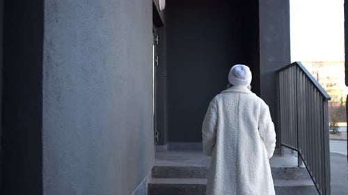 Woman Walking Up Stairs and Ringing Doorbell