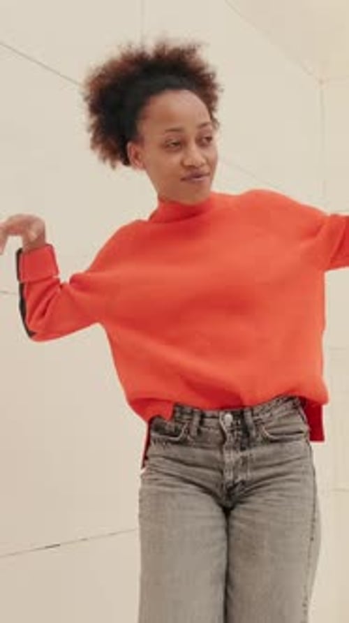 Woman Dancing and Moving in Orange Sweater