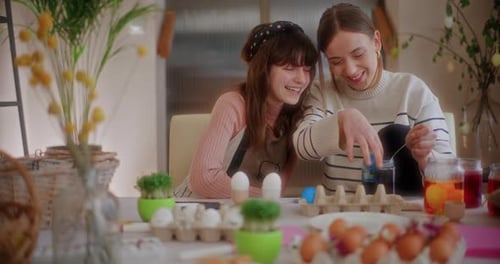 Mãe e filha estão pintando ovos de Páscoa para as férias da Páscoa