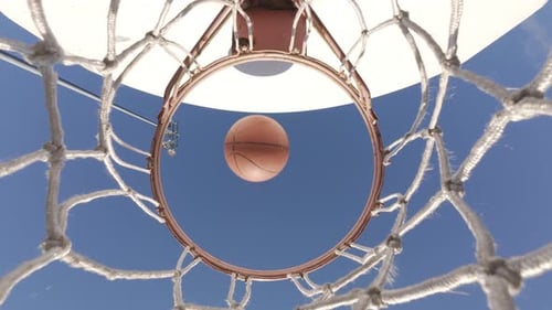 Basketball Captured Entering The Hoop With A Clean Net Swirl In Slow Motion