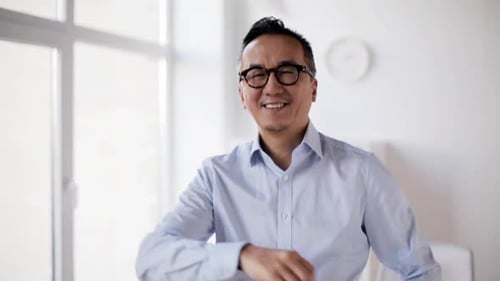 Happy Asian Businessman Waving Hello at Office