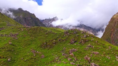 Majestic Mountain Peaks and Floating Clouds – Drone Aerial View of Lush Green Valley