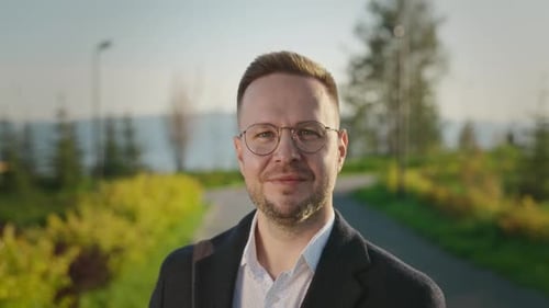 Confident Man with Beard Wearing Glasses Outdoors
