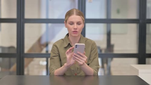 Mature Adult Woman Shocked by Loss on Phone in Office