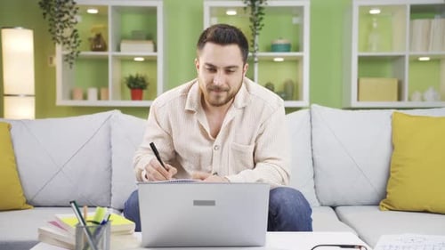 Man Video Conferencing on Laptop While Working From Home