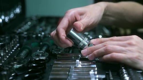 Close Up Hands Selecting Socket Wrench from Toolbox