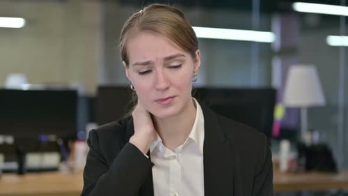 Businesswoman Rubbing Neck in Office Setting