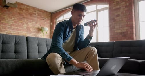 Adult Using Laptop and Phone Indoors