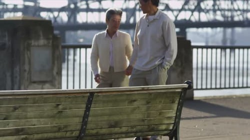 Senior Couple Sit Together on Bench at Waterfront Park 50-55