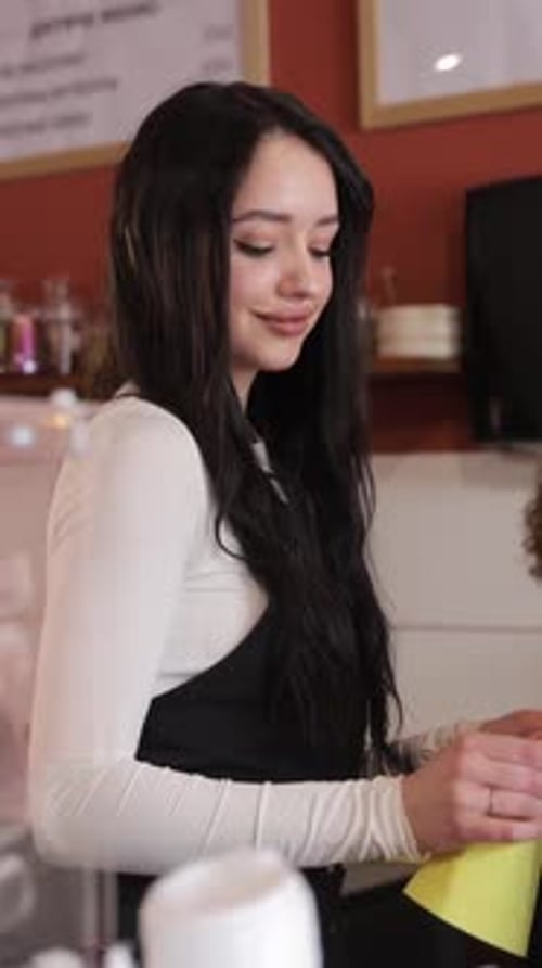 Young Female Barista Smiling at the Counter